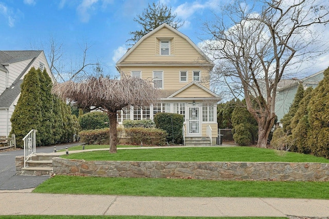 view of front of property featuring a front yard and a gambrel roof