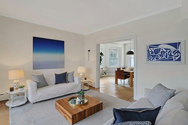 living room with a baseboard heating unit, baseboards, and crown molding