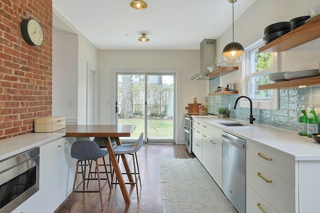 kitchen with open shelves, a sink, stainless steel appliances, decorative backsplash, and dark wood-style flooring