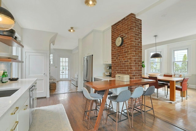 dining room with plenty of natural light, baseboards, and light wood-type flooring