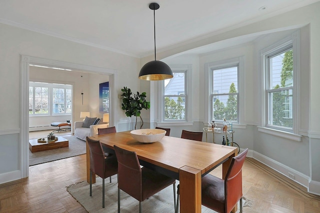 dining space with a baseboard radiator, baseboards, and crown molding