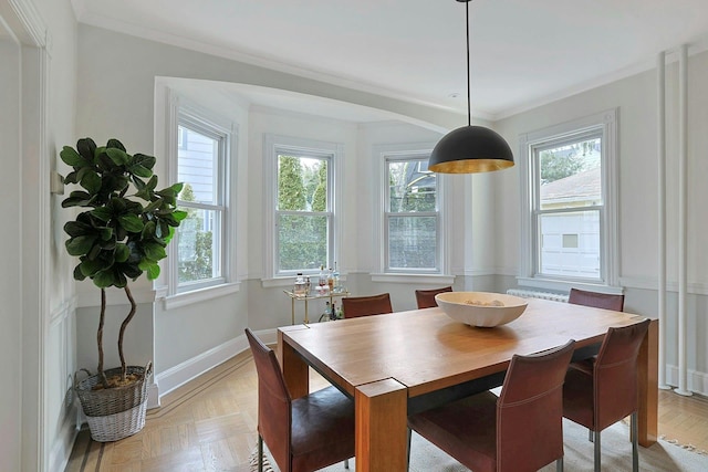 dining room featuring crown molding and baseboards