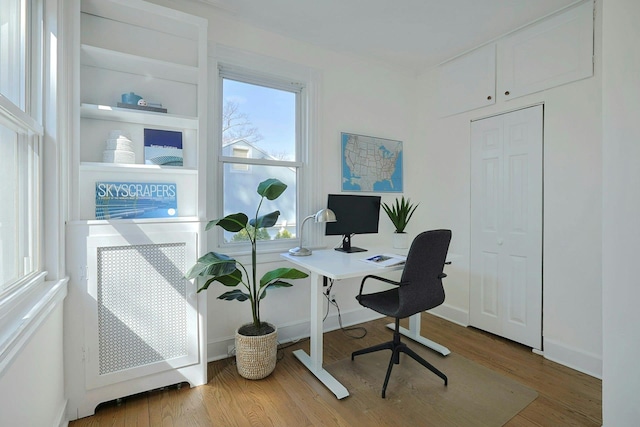 home office featuring wood finished floors and baseboards