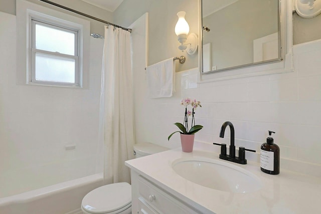 bathroom with tile walls, vanity, toilet, and shower / bath combo with shower curtain