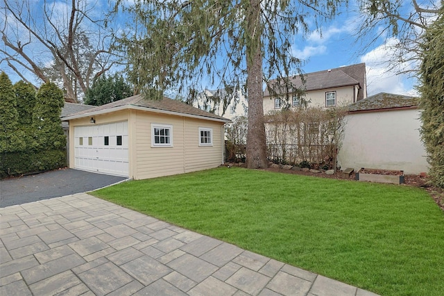 view of yard featuring an outdoor structure, fence, and a detached garage