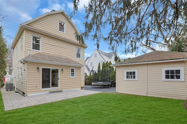 back of property featuring a patio, central air condition unit, a trampoline, and a yard