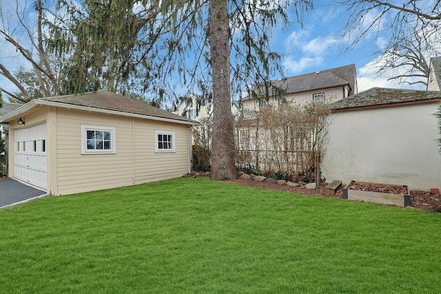 view of yard featuring an outdoor structure, fence, and a detached garage