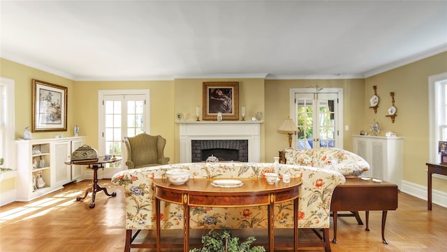 living room featuring light parquet flooring, a brick fireplace, a healthy amount of sunlight, and crown molding