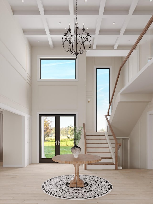 entryway featuring french doors, stairway, a high ceiling, a chandelier, and light wood-type flooring