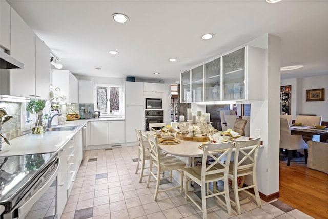 kitchen featuring sink, light tile patterned floors, stainless steel appliances, and white cabinets