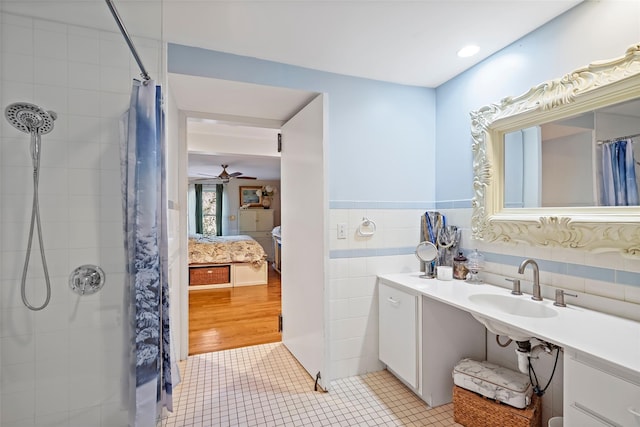 bathroom featuring walk in shower, tile patterned floors, sink, tile walls, and ceiling fan