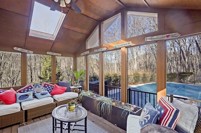 sunroom with vaulted ceiling with skylight, wooden ceiling, and ceiling fan