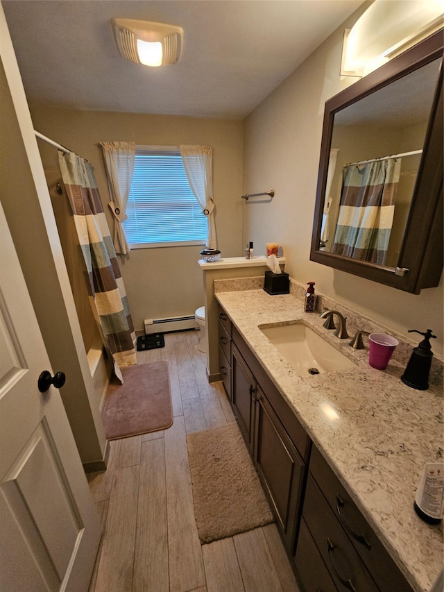 bathroom featuring hardwood / wood-style flooring, vanity, toilet, and baseboard heating