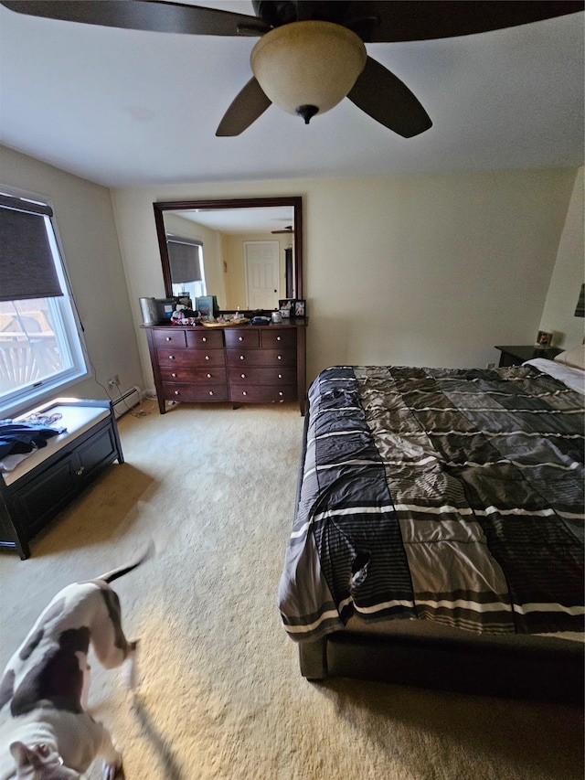 carpeted bedroom with baseboard heating and ceiling fan