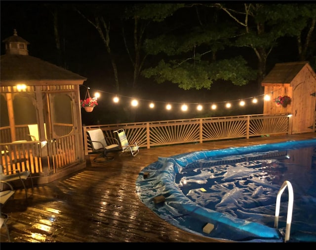 deck at twilight featuring a gazebo