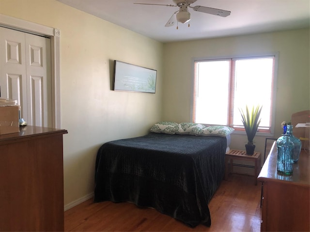 bedroom featuring ceiling fan, dark hardwood / wood-style floors, a closet, and a baseboard radiator