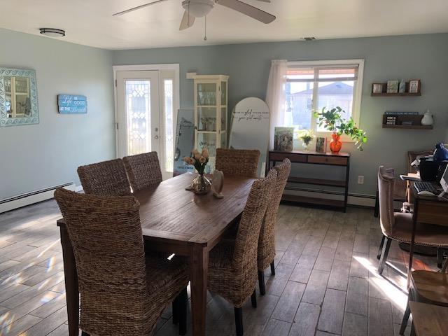 dining area with wood-type flooring, french doors, ceiling fan, and baseboard heating