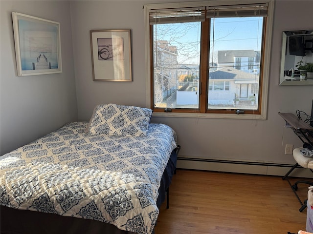 bedroom featuring a baseboard radiator and hardwood / wood-style floors