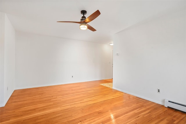 spare room with light hardwood / wood-style flooring, ceiling fan, and a baseboard heating unit