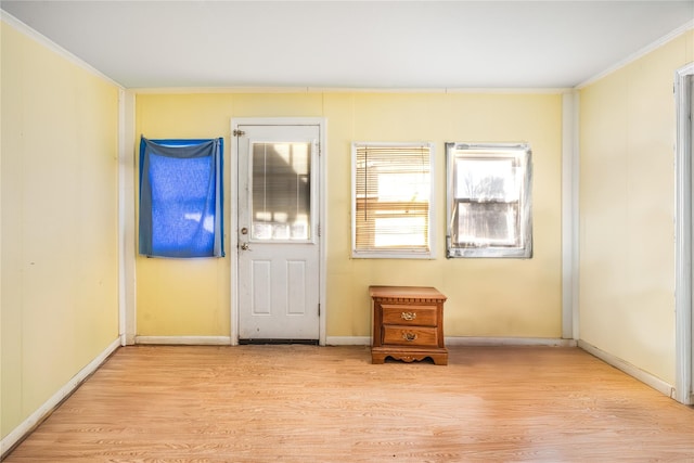 doorway to outside featuring light hardwood / wood-style floors and crown molding