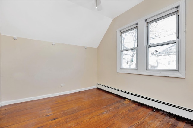 additional living space featuring vaulted ceiling, hardwood / wood-style flooring, and a baseboard radiator