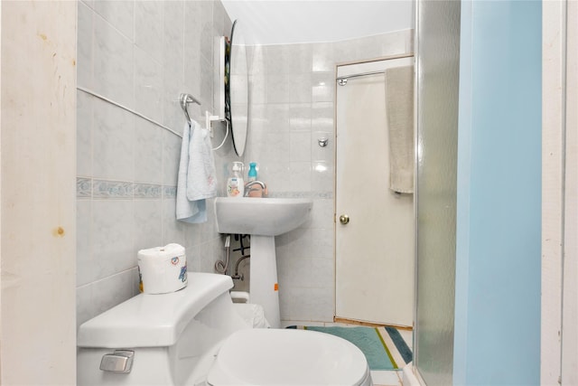 bathroom featuring toilet, tile walls, and an enclosed shower