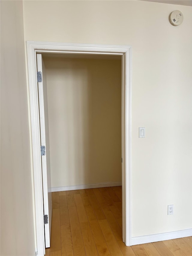 hallway with light hardwood / wood-style floors