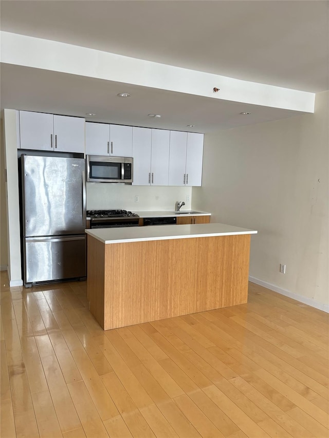 kitchen with a center island, white cabinets, and appliances with stainless steel finishes