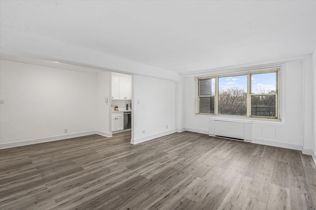 unfurnished living room with wood-type flooring and radiator heating unit