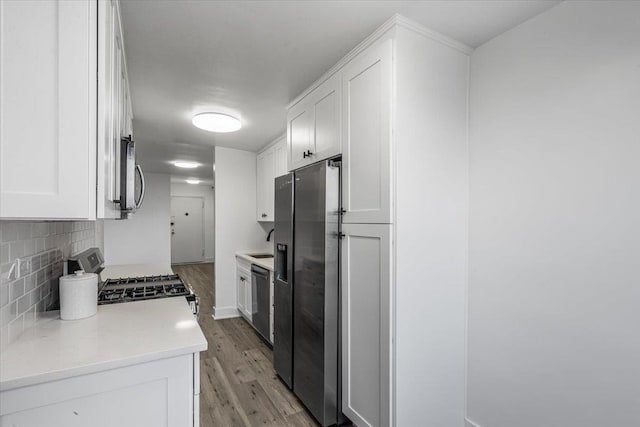 kitchen featuring backsplash, stainless steel fridge with ice dispenser, white cabinets, and range