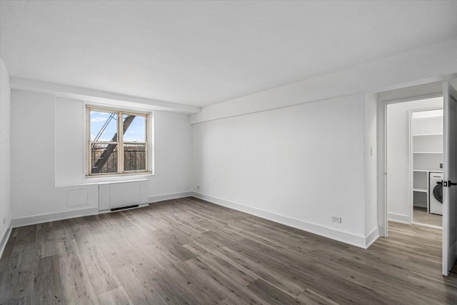 unfurnished room with dark wood-type flooring and washer / clothes dryer