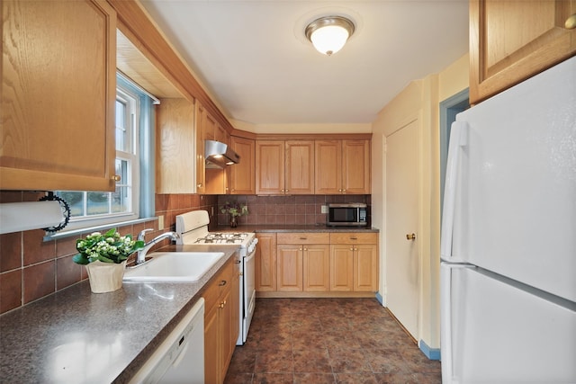 kitchen featuring backsplash, sink, and white appliances