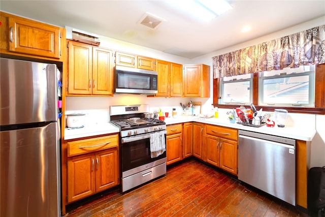 kitchen with stainless steel appliances and dark hardwood / wood-style floors