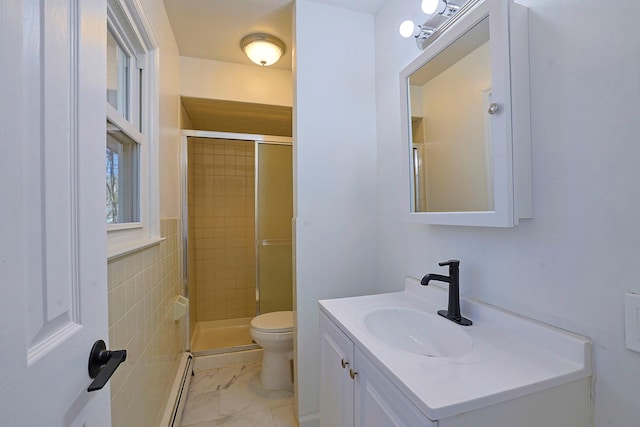 bathroom with vanity, baseboard heating, toilet, and an enclosed shower