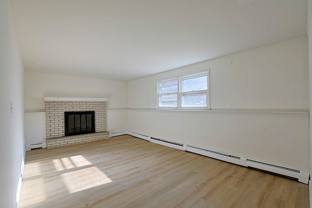 unfurnished living room with a fireplace, a baseboard radiator, and light hardwood / wood-style flooring