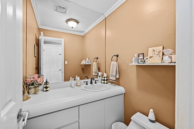 bathroom featuring toilet, vanity, and ornamental molding