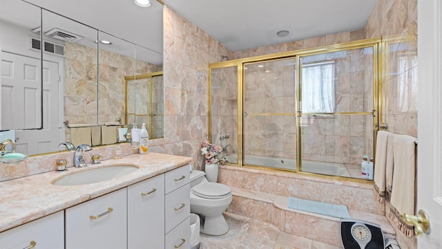 full bathroom with vanity, toilet, enclosed tub / shower combo, and tile walls