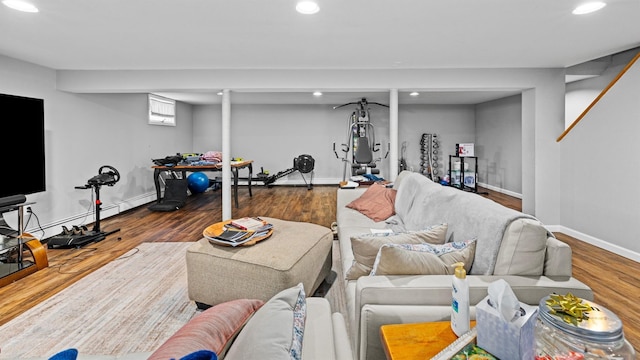 living room with wood-type flooring and a baseboard heating unit