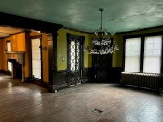 unfurnished dining area with radiator, crown molding, and a chandelier