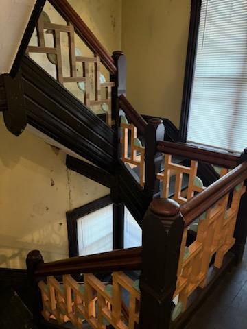 stairway featuring a wealth of natural light and hardwood / wood-style flooring