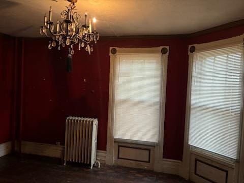 unfurnished dining area with radiator and an inviting chandelier