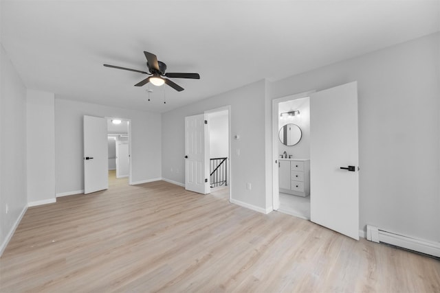 interior space with ensuite bathroom, light hardwood / wood-style flooring, ceiling fan, and a baseboard heating unit