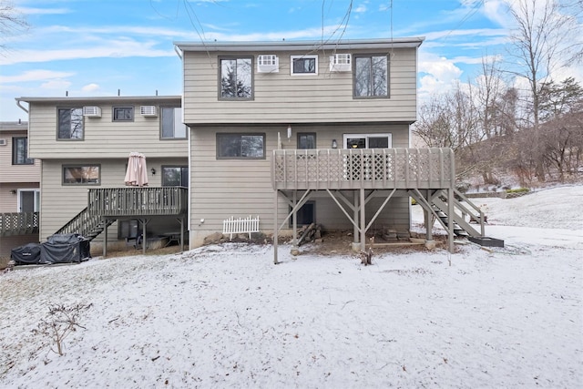 snow covered back of property featuring a deck