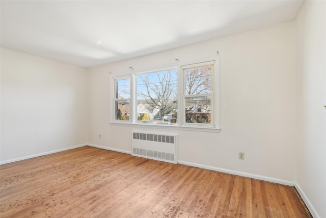 empty room with hardwood / wood-style floors and radiator