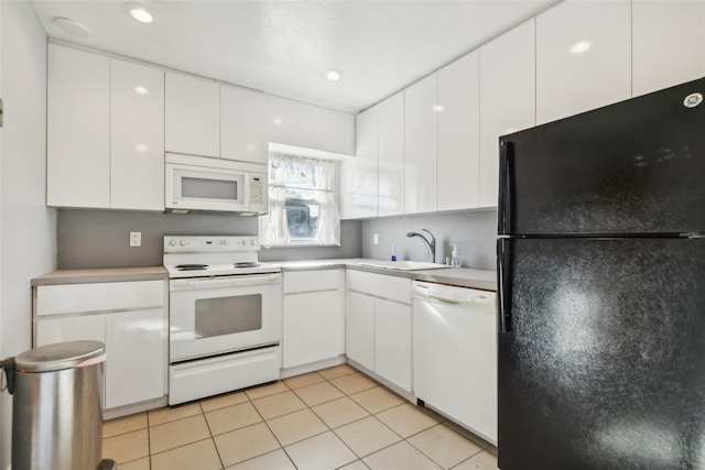 kitchen with white appliances, sink, light tile patterned floors, and white cabinets