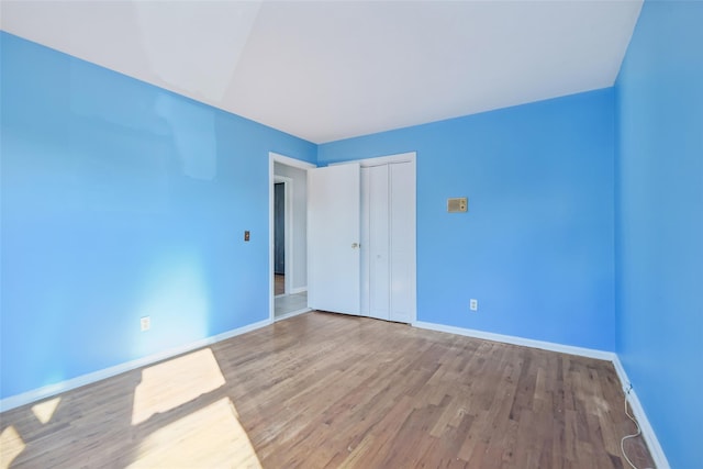 unfurnished bedroom with hardwood / wood-style floors and a closet