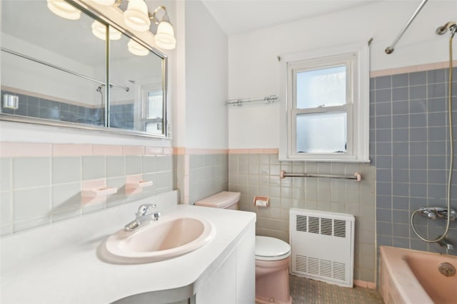 full bathroom with toilet, tile walls, shower / tub combination, radiator heating unit, and vanity