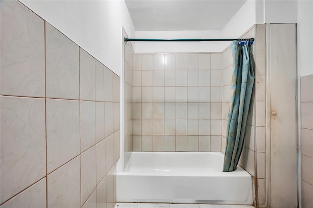 bathroom with tile walls and shower / tub combo with curtain