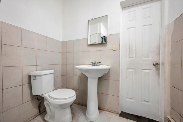 bathroom featuring toilet and tile walls