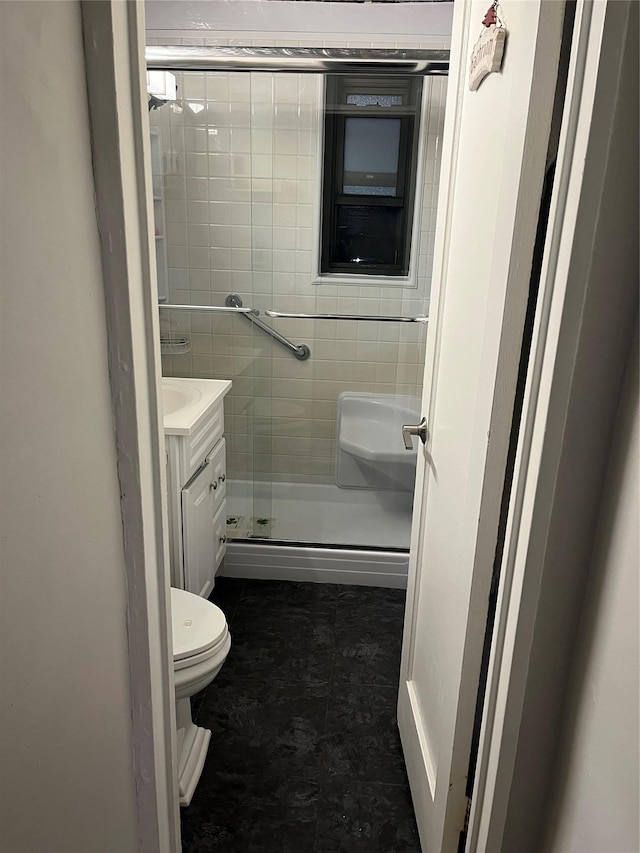 bathroom with vanity, toilet, and an enclosed shower